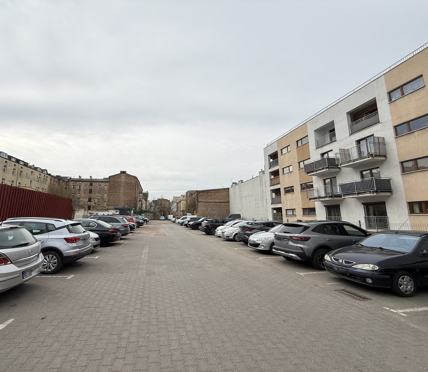 widok od strony ul. Dąbrowskiego, działka zabudowana, widok na parking