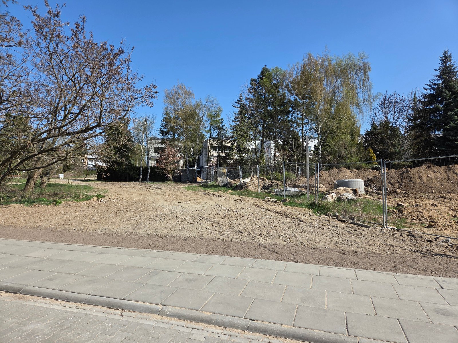 Działka przy ul. Jerzego Waldorffa, niezabudowana, porośnięta nieuporządkowaną roślinnością, pojedynczymi drzewami i krzewami